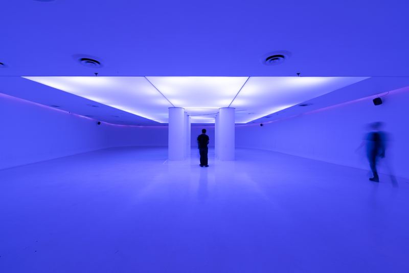 La sala en luz violeta con una persona al centro